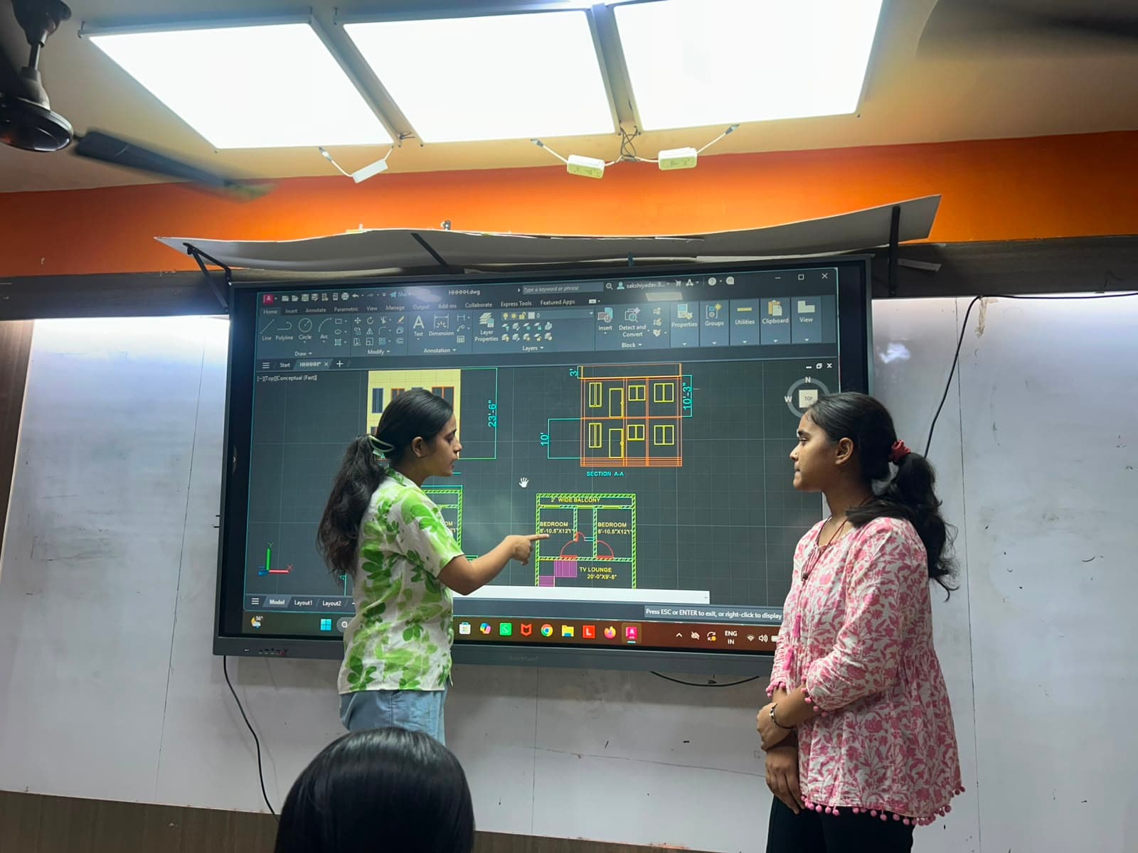 Students learning AutoCAD design on an interactive smart board